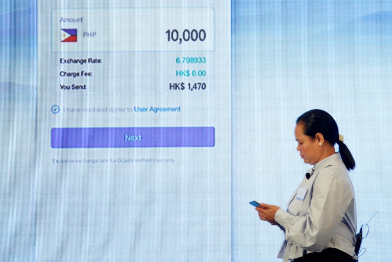 © Reuters. A Filipino guest demonstrates a blockchain-based remittance solution between Hong Kong and the Philippines during a news conference in Hong Kong