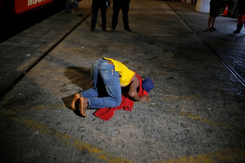 © Reuters. Imigrante beija o chão após desembarcar no porto da cidade espanhola de Málaga