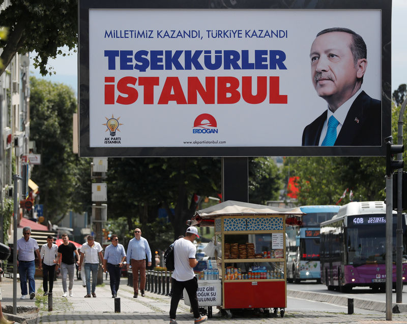 © Reuters. People walk past a poster for Turkey's President Tayyip Erdogan in Istanbul