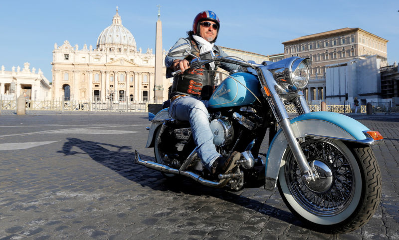 © Reuters. FILE PHOTO: A biker parks his motorcycle in front of St. Peter's square during the Harley-Davidson 110th Anniversary Party in Rome