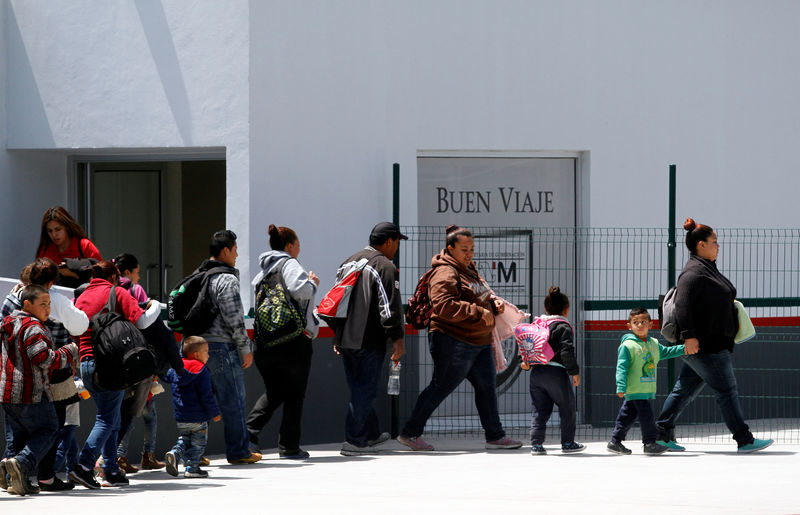 © Reuters. Familias migrantes caminan hacia una instalación de aduanas para pedir asilo en Estados Unidos