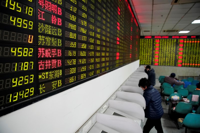 © Reuters. Investidores observam dados de ações em casa de corretagem em Xangai, na China