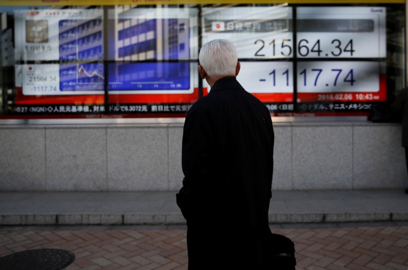 © Reuters. A man looks at an electronic board showing Japan's Nikkei average outside a brokerage in Tokyo