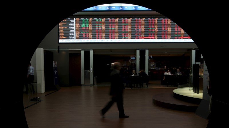 © Reuters. Homem passa por gráfico de flutuações de mercado na Bovespa, São Paulo, Brasil