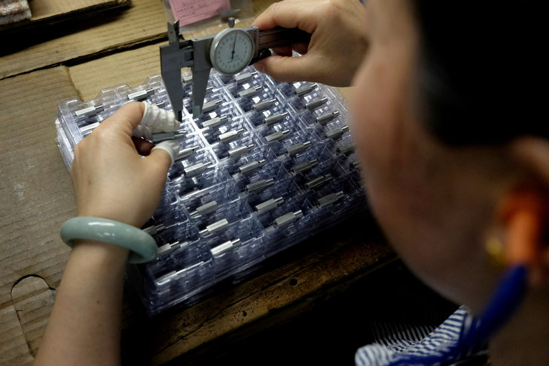 © Reuters. FILE PHOTO: A worker checks tailor-made magnetic stainless steel inside a factory in Dongguan