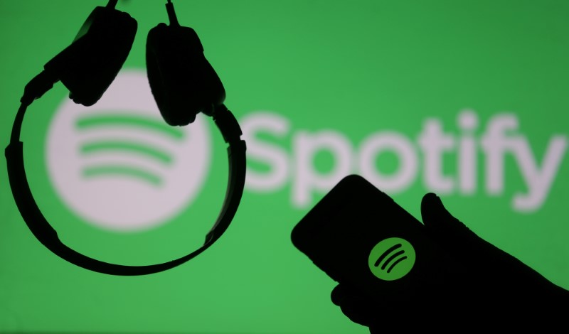 © Reuters. A smartphone and a headset are seen in front of a screen projection of Spotify logo, in this picture illustration