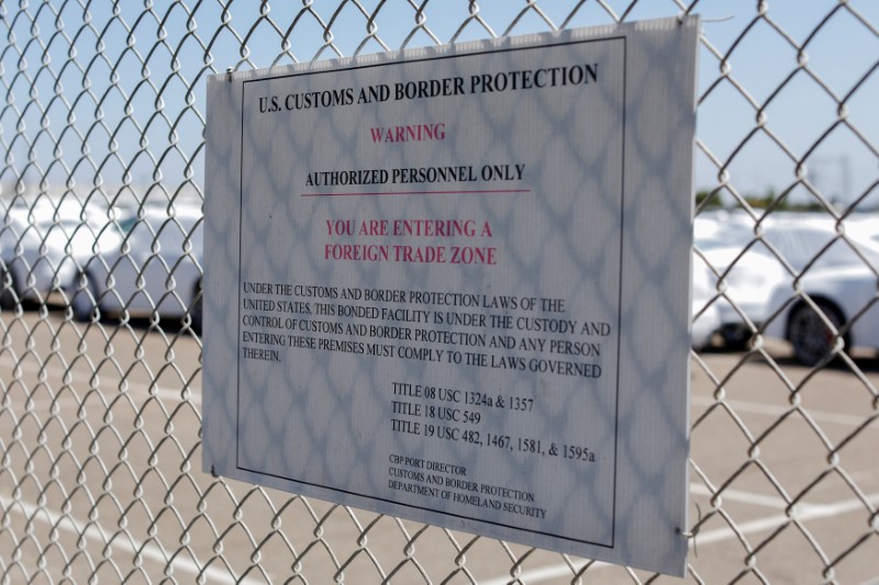 © Reuters. A U.S. Customs sign is shown on a fenced area holing imported vehicles after arriving in the United States in National City, California