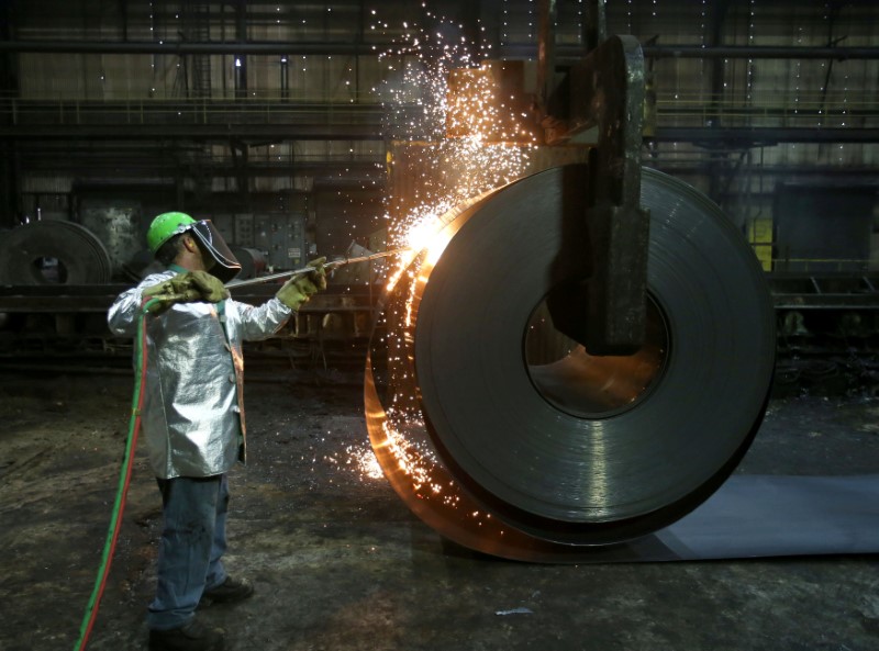 © Reuters. FILE PHOTO: A worker cuts a piece from a steel coil at the Novolipetsk Steel PAO steel mill in Farrell