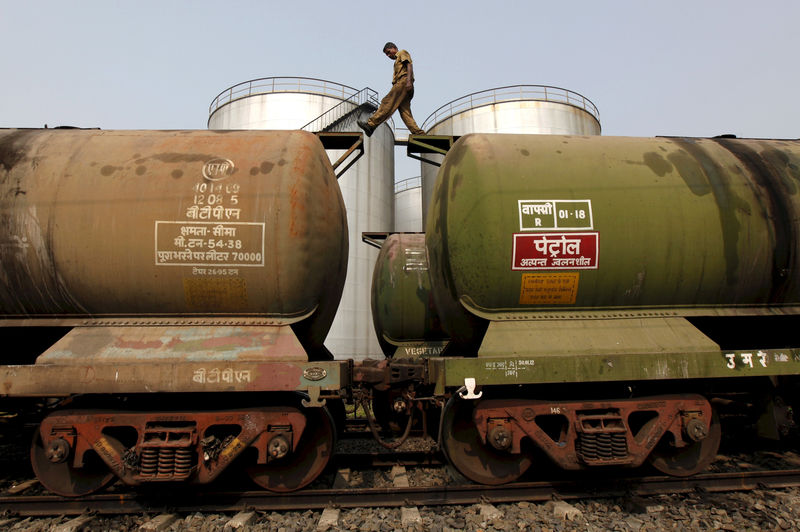 © Reuters. FILE PHOTO: A worker walking atop a tanker wagon to check the freight level at an oil terminal on outskirts of Kolkata