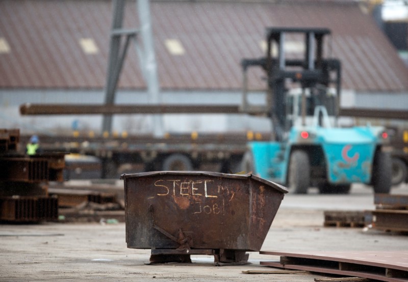 © Reuters. A garbage bin with the words "STEEL MY JOB!" painted on it sits in a storage yard where structural steel is loaded onto a truck in the portlands of Hamilton