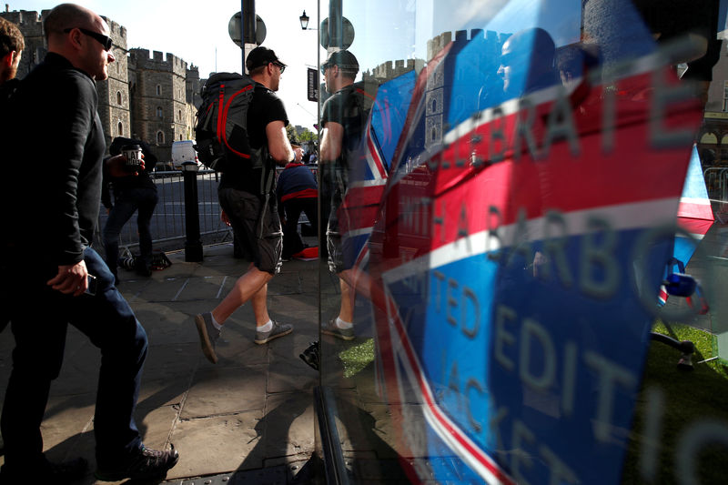 © Reuters. FILE PHOTO: People are reflected in the window of a gift shop as they walk past Windsor Castle in Windsor