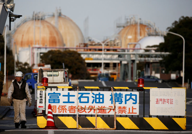 © Reuters. FILE PHOTO: A worker walks near an entrance gate of Fuji Oil Co.'s Sodegaura Refinery in Sodegaura