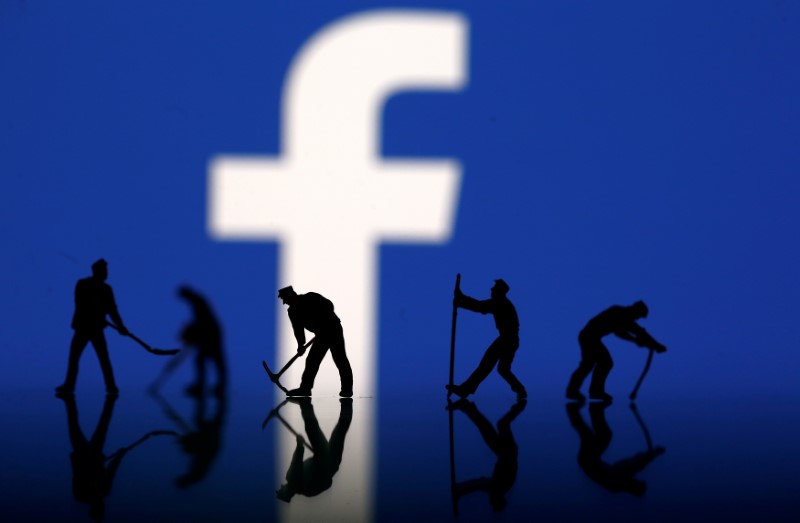 © Reuters. Figurines are seen in front of the Facebook logo in this illustration