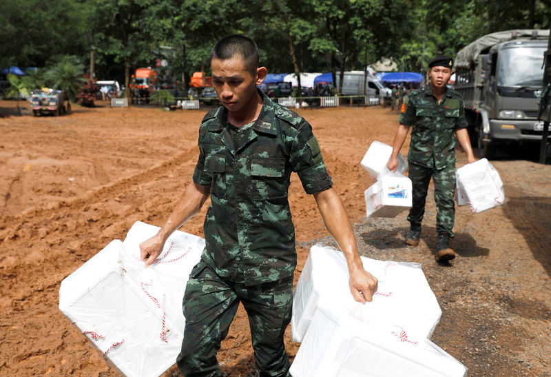 © Reuters. Soldados carregam kits de sobrevivência perto da caverna Tham Luang, na Tailândia