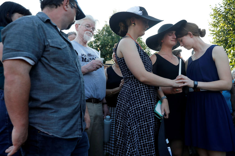© Reuters. People hold a candlelight vigil held near the Capital Gazette, the day after a gunman killed five people inside the newspaper's building in Annapolis, Maryland, U.S.