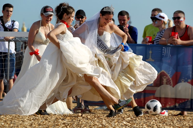 © Reuters. مباراة كرة قدم ودية بين روسيات يرتدين أثواب زفاف