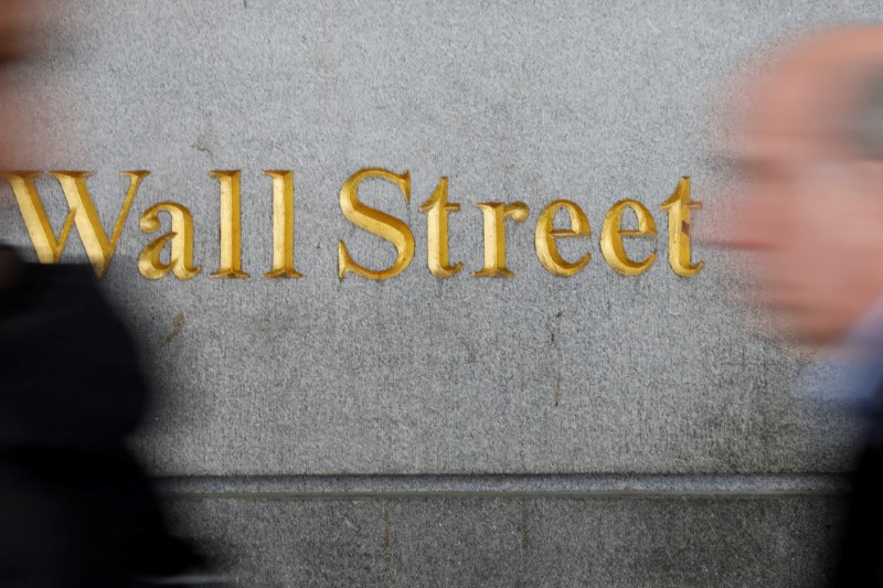 © Reuters. FILE PHOTO: People walk by a Wall Street sign close to the NYSE in New York