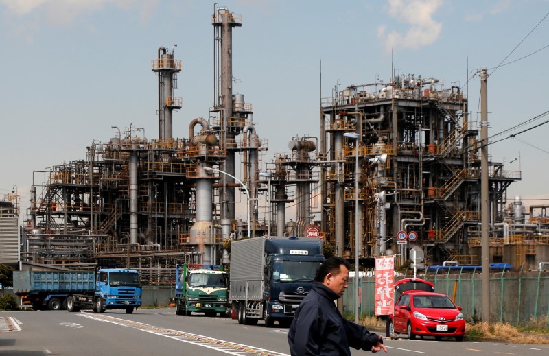 © Reuters. Worker walks near a factory at the Keihin industrial zone in Kawasaki