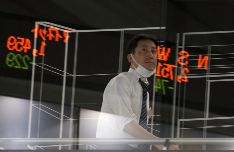 © Reuters. FILE PHOTO: A visitor is seen as market prices are reflected in a glass window at the TSE in Tokyo