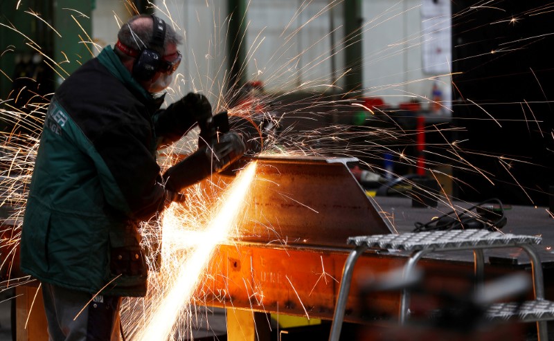 © Reuters. FILE PHOTO: A worker grinds metal at the machine-building company Zemmler Siebanlagen in Massen, Germany