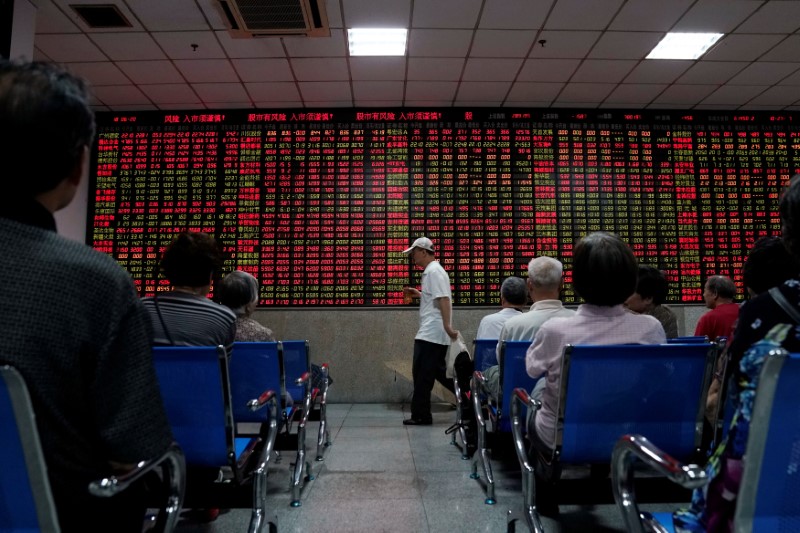 © Reuters. Investors look at an electronic board showing stock information at a brokerage house in Shanghai