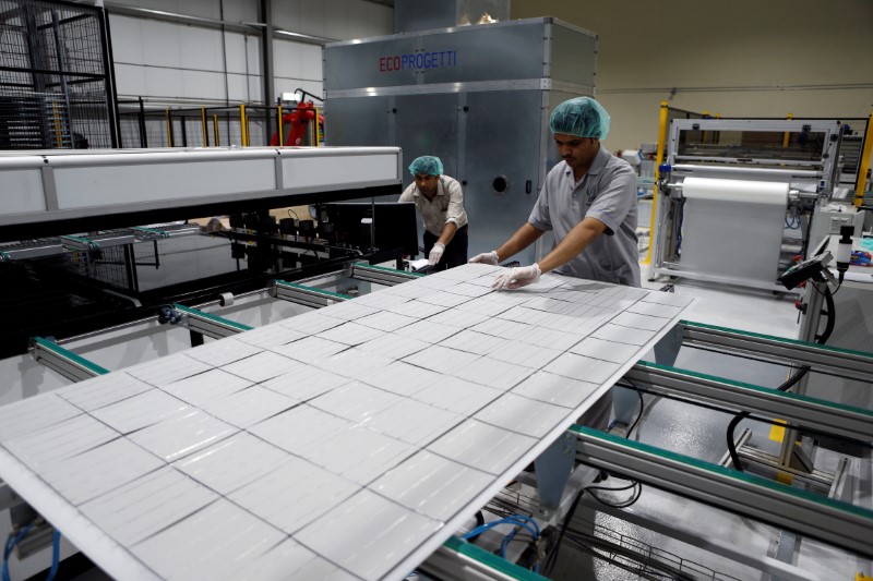 © Reuters. Workers are seen at the solar plant factory in Uyayna, north of Riyadh