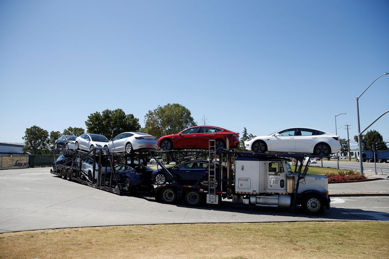 © Reuters. FILE PHOTO - A car carrier trailer carries Tesla Model 3 electric sedans, is seen outside the Tesla factory in Fremont