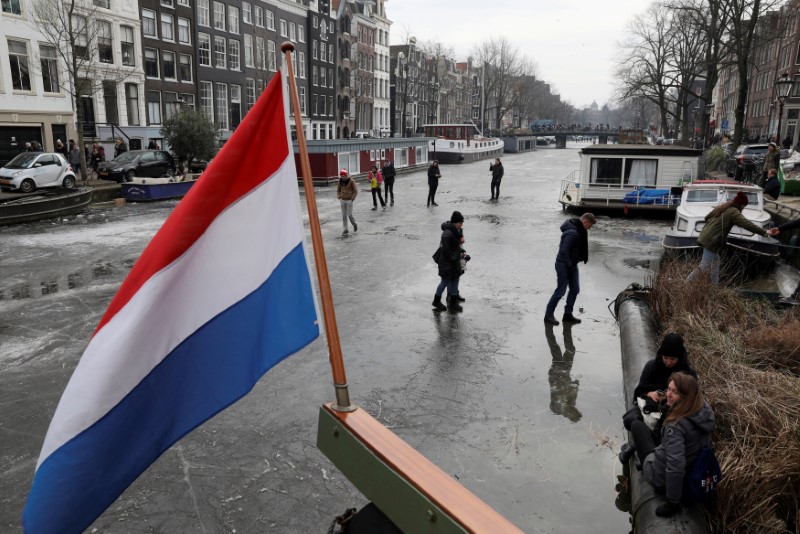 © Reuters. FILE PHOTO: Ice skaters skate on the frozen Prinsengracht canal during icy weather in Amsterdam