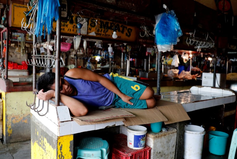 © Reuters. A vendor rests in an empty meat stall at a food market in Las Pinas