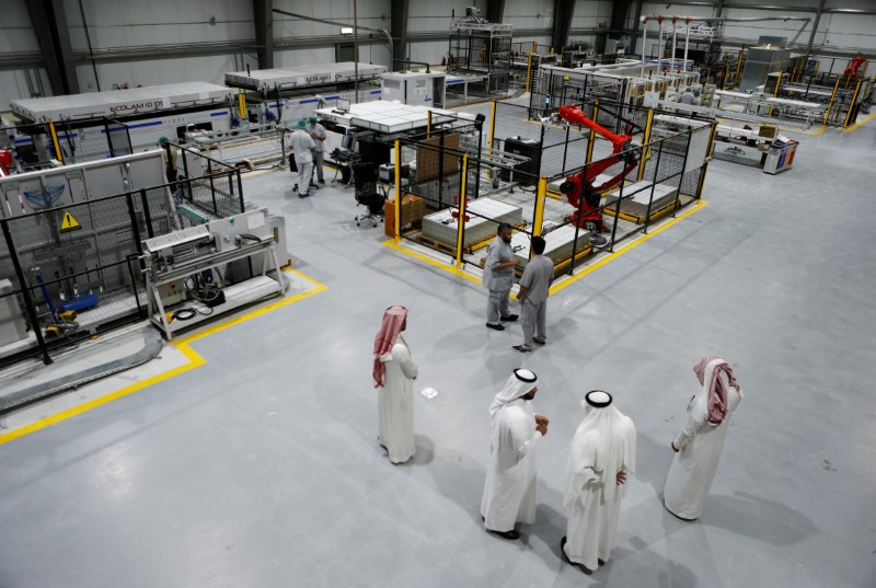 © Reuters. Workers are seen at the solar plant factory in Uyayna, north of Riyadh