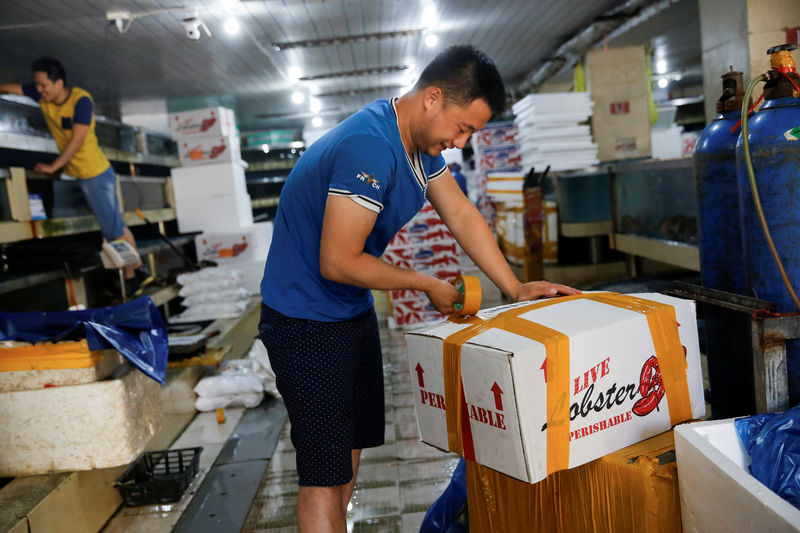 © Reuters. FILE PHOTO: A customer closes a box of lobsters that are imported from the U.S. at a seafood retailer at a fish market in Beijing