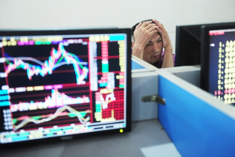 © Reuters. Man looks at a monitor showing stock information at a brokerage house in Fuyang