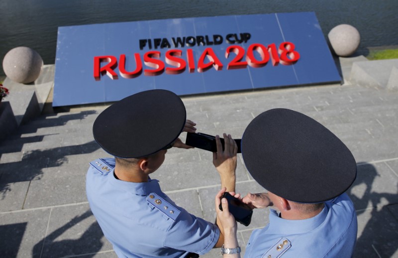 © Reuters. FILE PHOTO: Russian police officers hold their mobile phones as they guard area before preliminary draw for 2018 World Cup in St. Petersburg