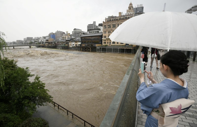 © Reuters. Mulher tira foto do rio Kamo em Kyoto, no Japão