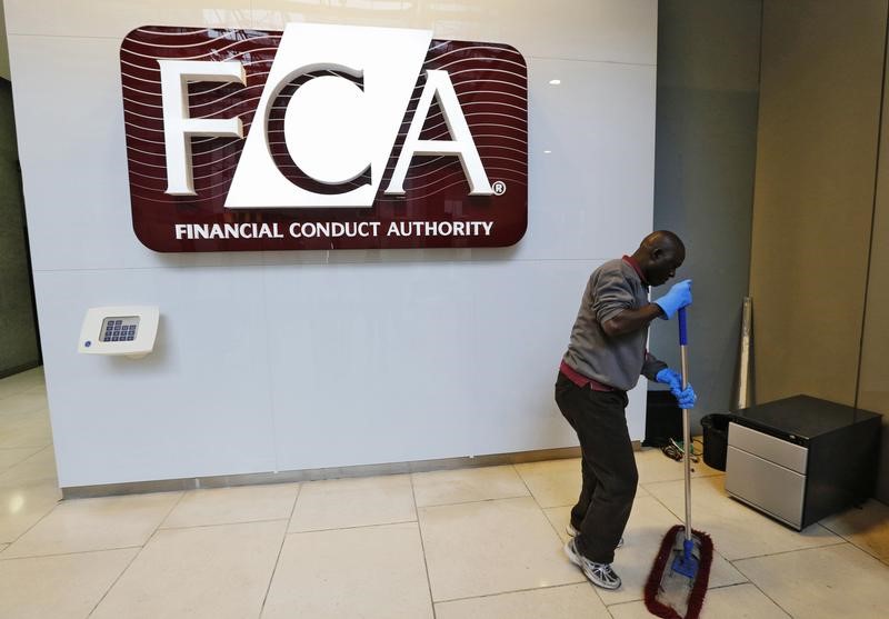 © Reuters. A maintenance worker cleans the entrance area of the headquarters of the new Financial Conduct Authority in the Canary Wharf business district of London