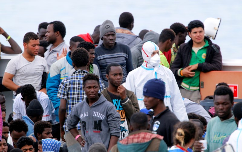 © Reuters. Imigrantes aguardam para desembarcar em porto de Catania, na Itália