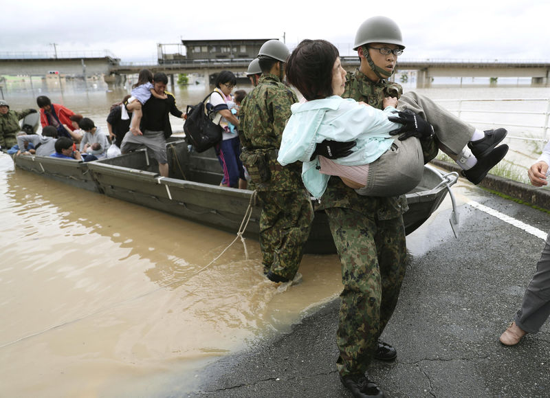 © Reuters. Residents are rescued from a flooded area by Japan Self-Defense Force soldiers in Kurashiki
