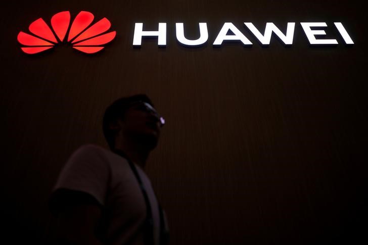 © Reuters. A man walks past a sign board of Huawei at CES (Consumer Electronics Show) Asia 2018 in Shanghai