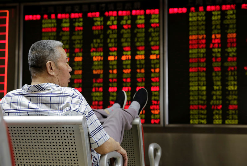 © Reuters. FILE PHOTO: An investor watches stock prices at a brokerage office in Beijing