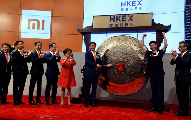 © Reuters. Xiaomi founder, Chairman and CEO Lei Jun hits the gong during the listing of the company at the Hong Kong Exchanges in Hong Kong