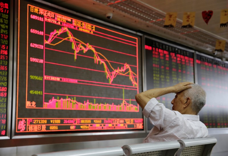 © Reuters. An investor looks at a board showing stock information at a brokerage office in Beijing
