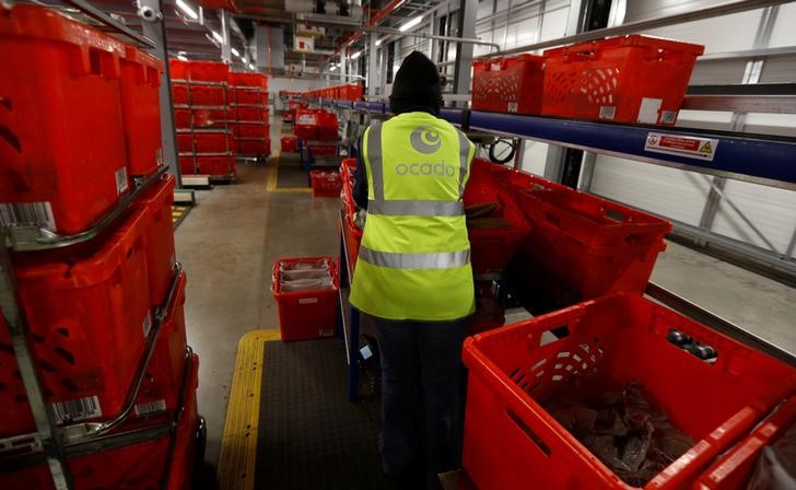 © Reuters. A worker cleans returned shopping baskets at the Ocado CFC (Customer Fulfilment Centre) in Andover