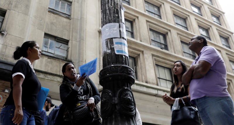 © Reuters. Pessoas olham para anúncios de empregos em rua no centro de São Paulo