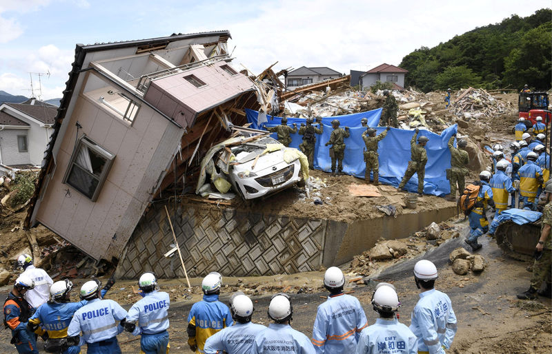 © Reuters. Equipes de resgate fazem buscas por pessoas desaparecidas em casa derrubada pela chuva na cidade japonesa de Kumano