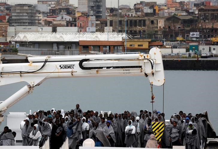 © Reuters. Imigrantes aguardam para desembarcar de embarcação da Guarda Costeira italiana em porto da Sicília