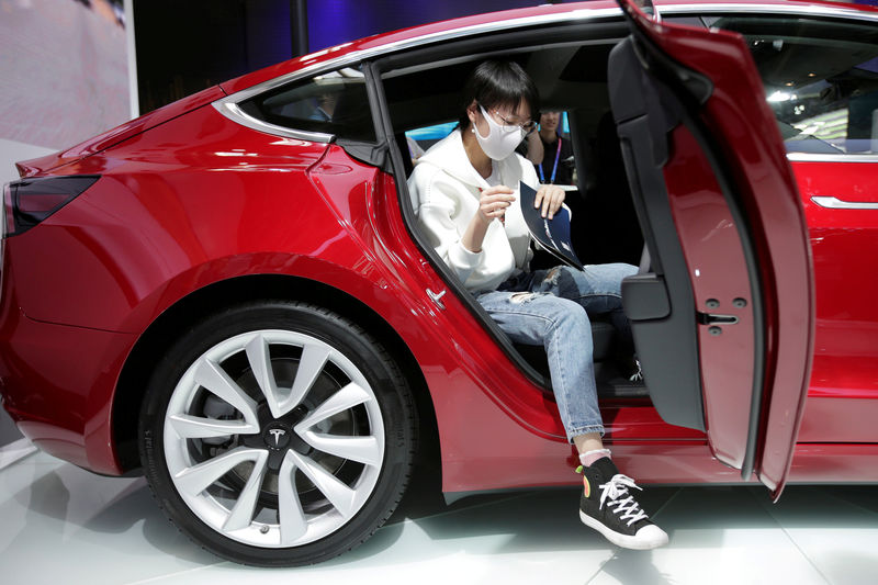 © Reuters. FILE PHOTO: A woman sits in a Tesla Model 3 car during a media preview at the Auto China 2018 motor show in Beijing