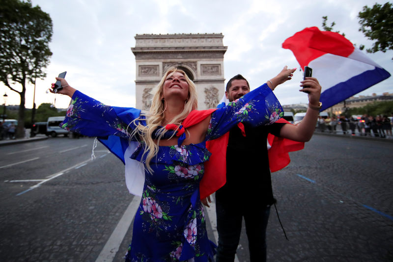 © Reuters. Hinchas franceses festejan frente al Arco del Triunfo, en los Campos Elíseos en París, el paso de su selección a la final de la Copa del Mundo de la FIFA al derrotar a Bélgica