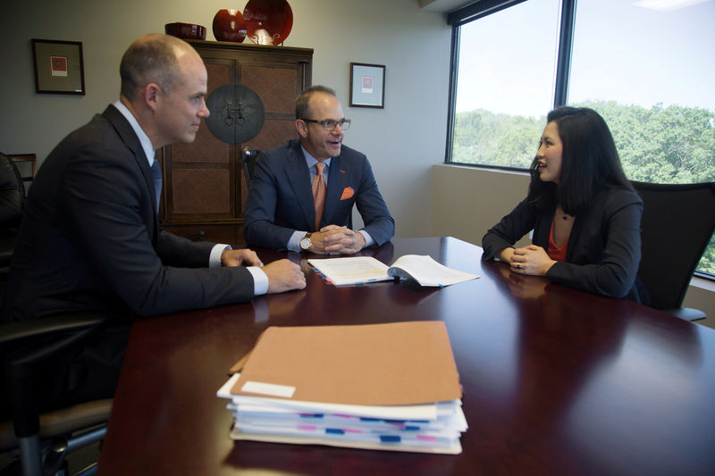 © Reuters. FILE PHOTO: Attorney Reid, who represents the hedge fund Highland Capital in its lawsuit against Credit Suisse, reviews a credit agreement for the Lake Las Vegas project with colleagues Palmer and Tsai in Austin