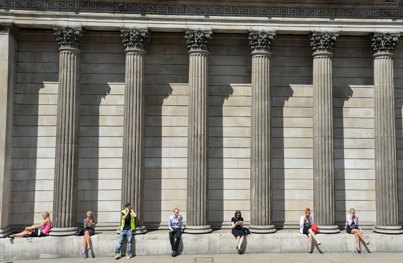 © Reuters. FILE PHOTO: Workers relax during the lunch hour outside the Bank of England in the City of London