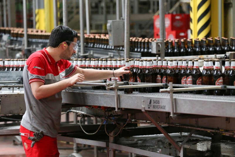 © Reuters. A worker inspects bottles of beer on the production line at the Birra Peroni beer factory in Rome